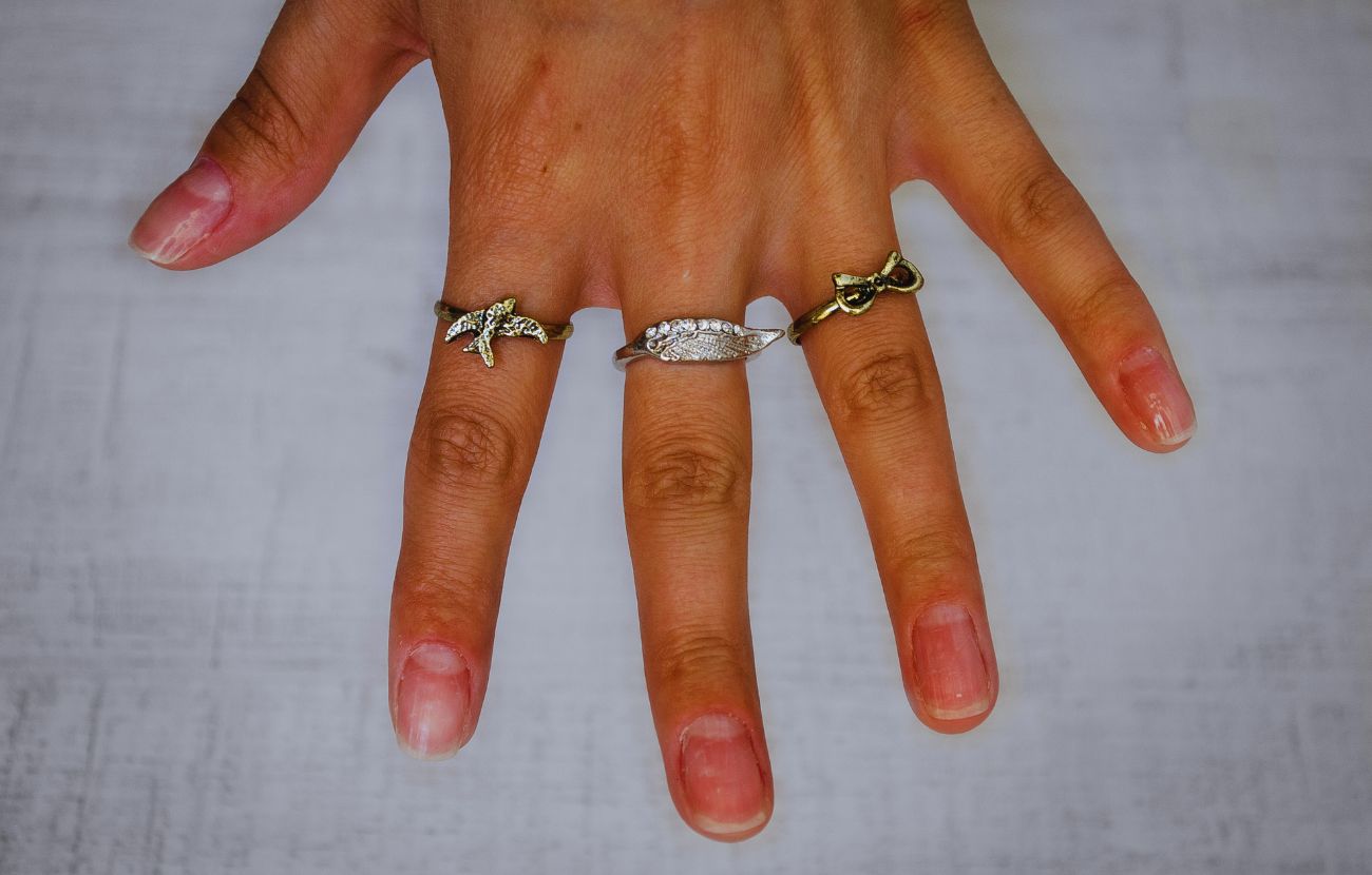 Una mano femminile con numerosi anelli